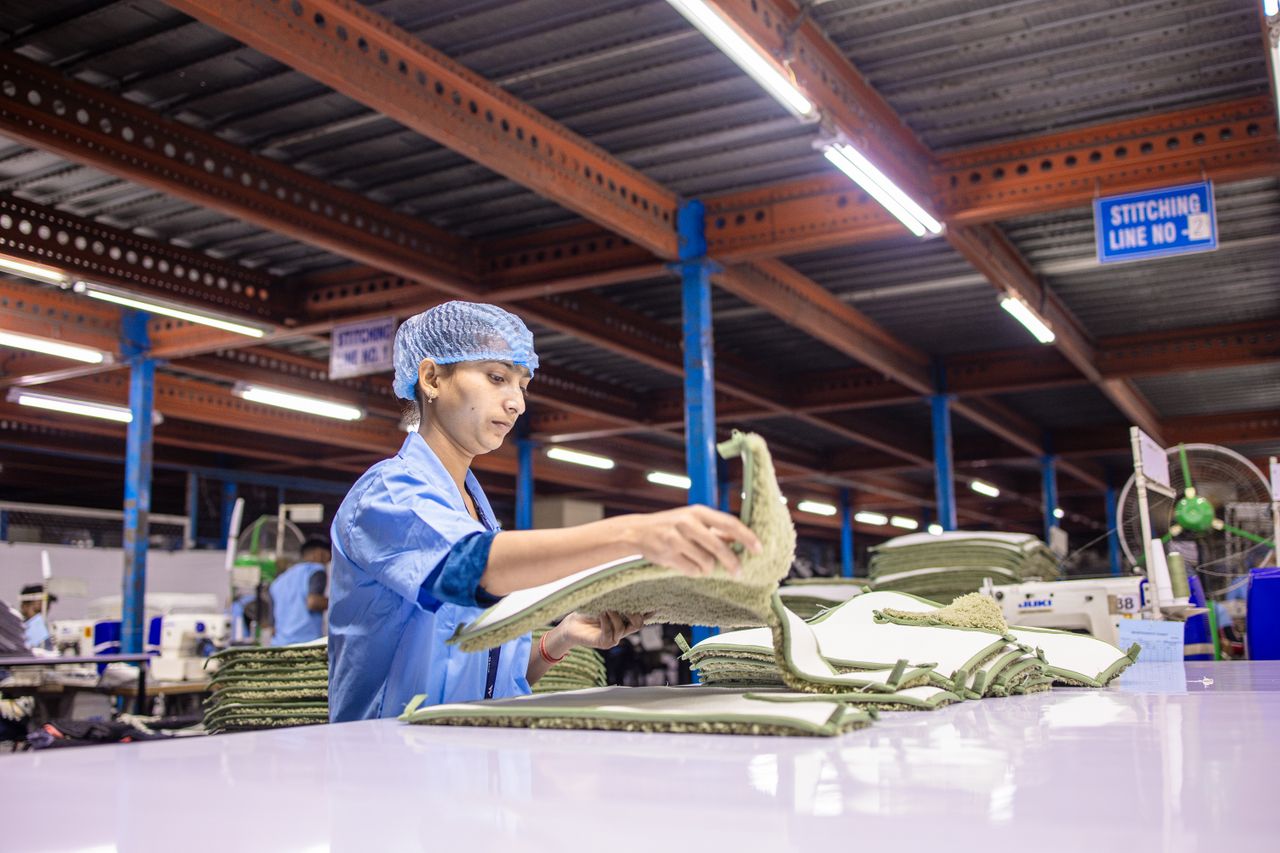 The Art of Drawing Readers In: Your attractive post title goes here Indian factory worker sorting textile fabric in an industrial setting.