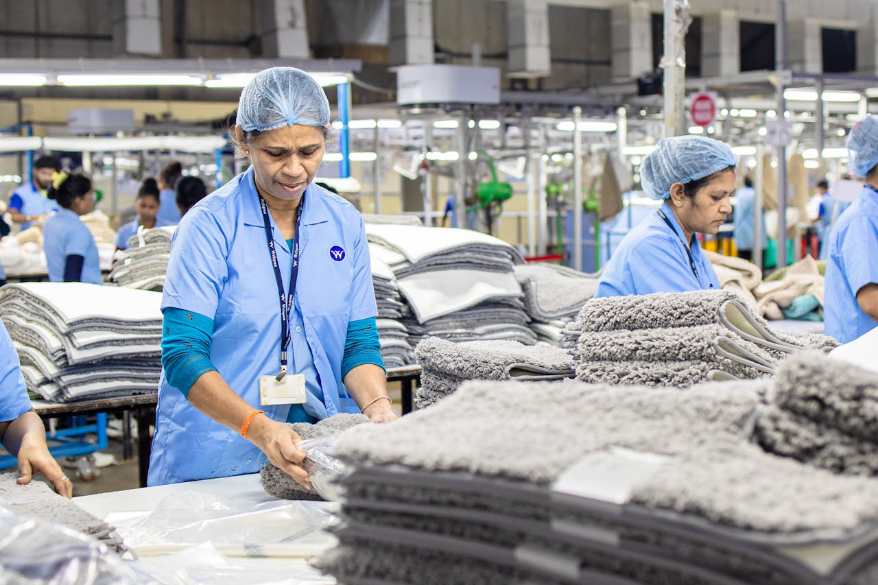 Crafting Captivating Headlines: Your awesome post title goes here Focused textile factory workers organizing materials efficiently indoors.